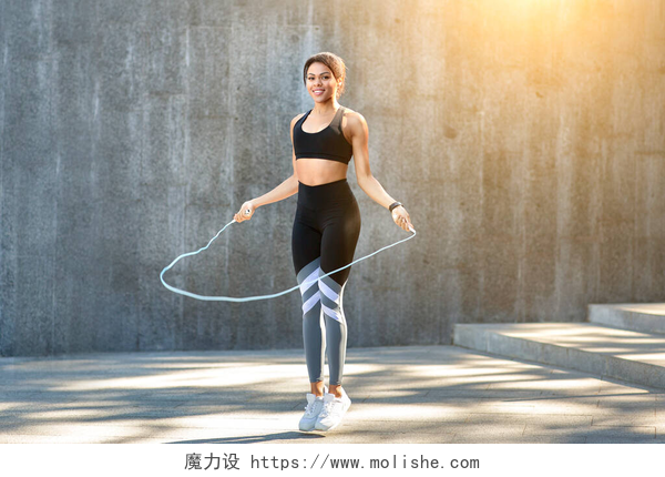 一个女人在跳绳运动快乐的黑人女运动员跳着跳绳到户外